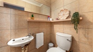 Ein Badezimmer mit Waschbecken, Toilette und Ablagefläche mit Dekoration.