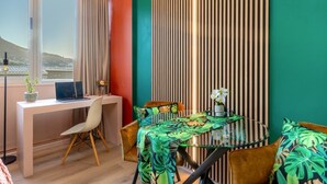 Ein modernes Zimmer mit Schreibtisch, Stuhl und rundem Tisch mit Glasplatte.