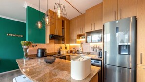 Eine moderne Küche mit einer Granit-Arbeitsplatte, Edelstahlgeräten und Holzschränken.