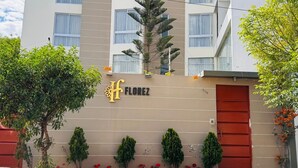 A multi-story hotel with a beige facade, a red entrance door, and a sign reading "FLOREZ". - hotel florez boutique (Arequipa)