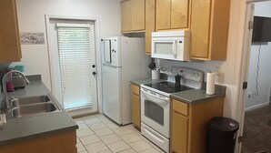 A compact kitchen with a refrigerator, microwave, stove, and sink. - 3 Bedroom 3 Bath Townhome Cul-de-Sac (Tallahassee)