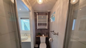 A modern bathroom with a toilet, sink, and shower. - Charming and Cozy Furnished 2-person Studio Apartment (De Koog)