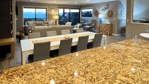 Amplia sala de estar con comedor grande, cocina y vista al océano.
