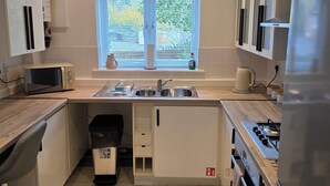 A modern kitchen with a window, stainless steel appliances, and a trash bin. - School Path in the heart of the historic Ironbridge (Telford)