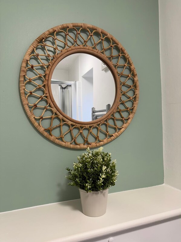 Un miroir rond avec un cadre tressé, accroché au mur.