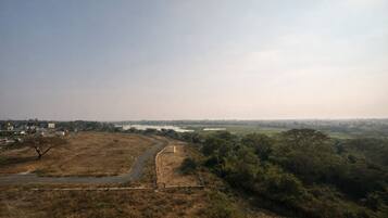 A wide, open landscape with a road curving through a dry, grassy area.
