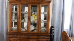 A wooden china cabinet with glass doors containing dishes and cups. - Villa Marita B&B in Middleburg (Middleburg)