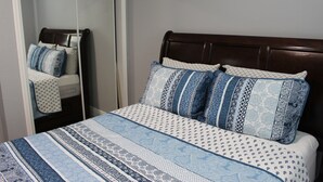 A bedroom with a bed, a wooden headboard, and patterned bedding. - Villa Marita B&B in Middleburg (Middleburg)