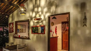 A room with a wooden table and chairs, a mirror, a framed picture, and a door leading to another room. - Pousada Atlantis (Jijoca de Jericoacoara)