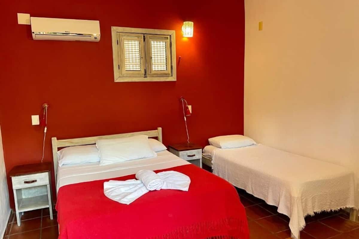 Habitación triple estándar, balcón, vista al jardín | Caja de seguridad en la habitación y tabla de planchar con plancha