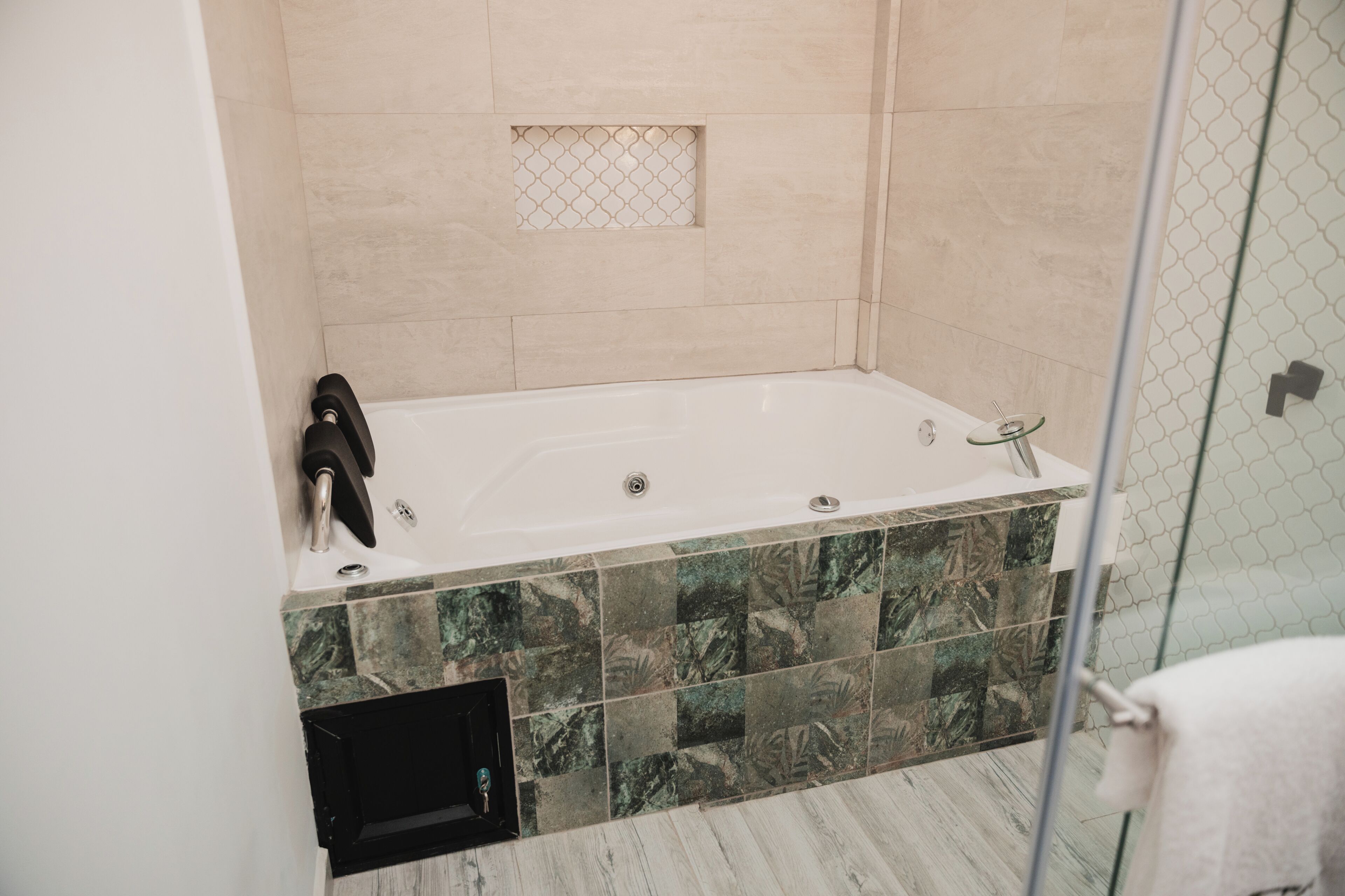 A modern bathroom with a freestanding bathtub, a glass shower enclosure, and a tiled floor.