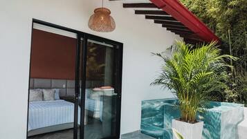 A modern bedroom with a glass door, a red awning, and a hanging light fixture.