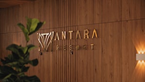 A wooden wall with the text "VANTARA RESORT" in metallic letters.