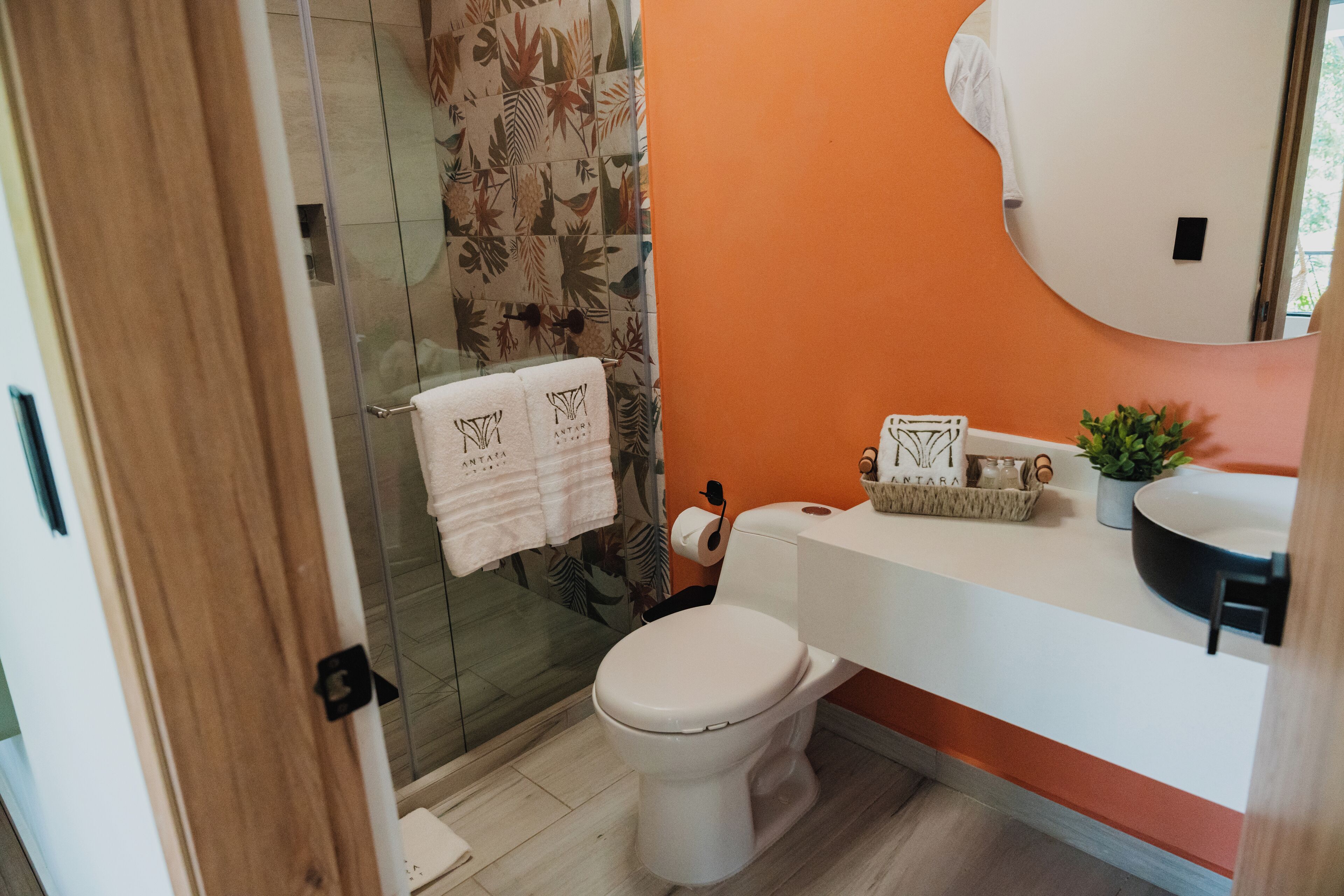 A bathroom with a toilet, sink, and shower area.