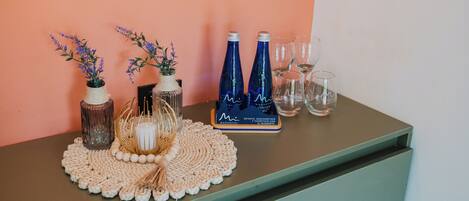 A table with decorative items including vases, a woven placemat, and wine bottles.