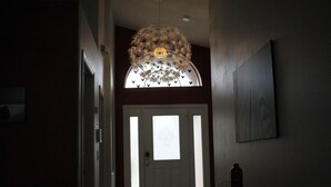 A hallway with a decorative ceiling light, a door with frosted glass panels, and a framed picture on the wall. - Dog Friendly:  Pleasant 4-bedroom pool and spa house near Disney with pool table (Kissimmee)