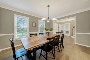 A dining room with a wooden table, black chairs, and a chandelier. - Kid-Friendly Near UD, 1st-Floor Master + Office (Newark)