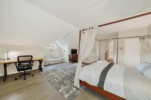 Ein Schlafzimmer mit einem Himmelbett, einem Schreibtisch mit Stuhl, einem Fernseher und einem Fenster.