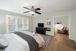 A bedroom with a bed, a TV, a ceiling fan, a dresser, and a chair. - Kid-Friendly Near UD, 1st-Floor Master + Office (Newark)