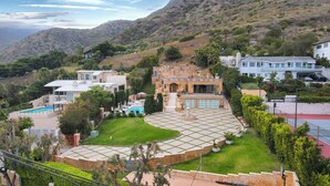 Una extensa propiedad con piscina, cancha de tenis y jardín paisajístico.