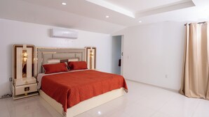 Un dormitorio moderno con una cama grande, mesitas de noche y una lámpara en el techo.