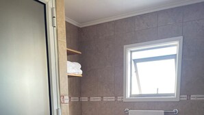 A bathroom with a toilet, a sink, a towel rack, and a window. - Casa lucy bed and breakfast. Familiar, comfortable, near to Natales center. (Puerto Natales)