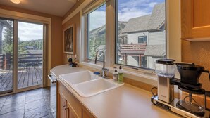 A kitchen with a large window, a coffee maker, and a sink. - Ski-in/out spacious 3BR Saddle Ridge townhome, steps to Ironhorse Lift & hot tub (Big Sky)