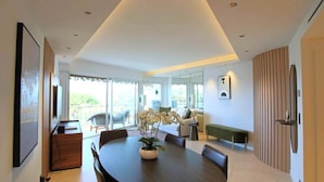 A modern dining area with a round table, chairs, and a potted plant. - Apartment on Croisette Near Palm Beach (Cannes)
