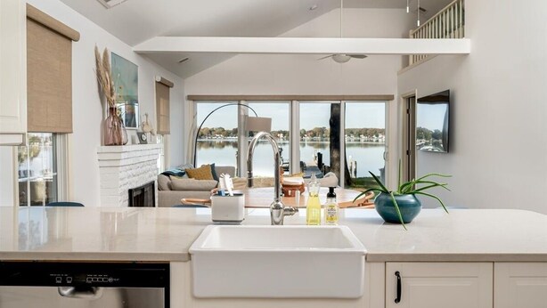 A modern kitchen with a large window, a dishwasher, and a ceiling fan. - Sunset Cottage - West River Access and Views! (Shady Side)
