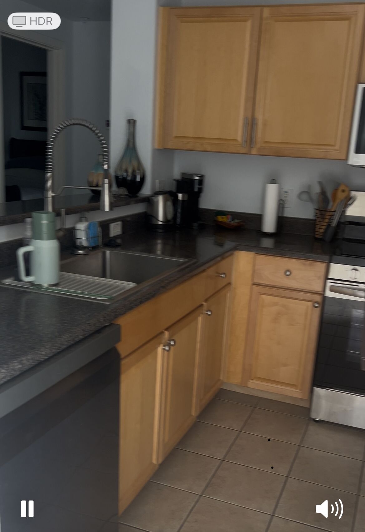 A kitchen with wooden cabinets, a stainless steel sink, and a coffee maker.