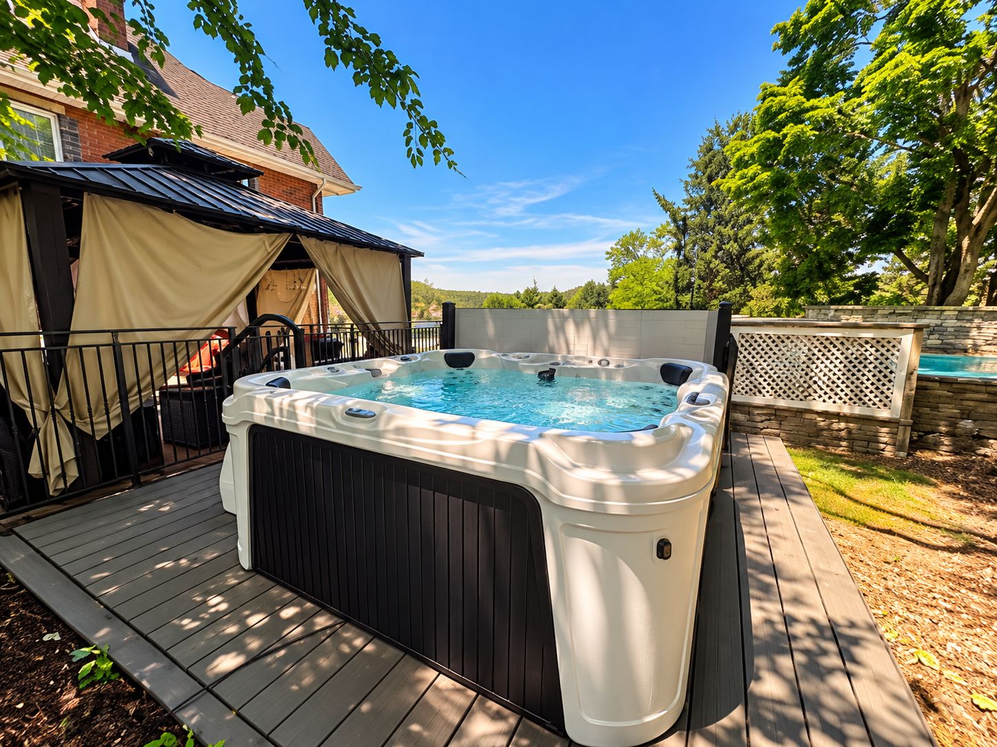 A hot tub on a wooden deck with a covered seating area and a pool in the background.