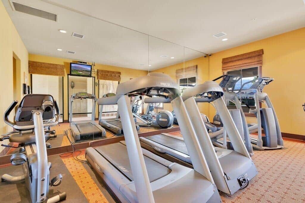 A gym with treadmills, elliptical machines, and a stationary bike.