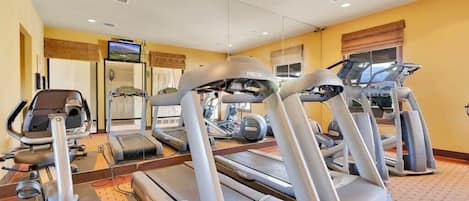 A gym with treadmills, elliptical machines, and a stationary bike.