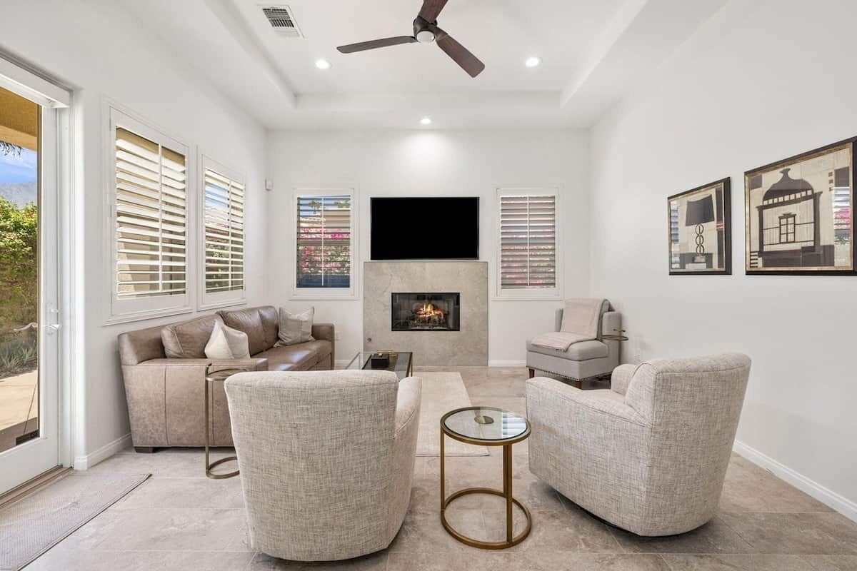 A living room with a fireplace, two sofas, a coffee table, and a television.