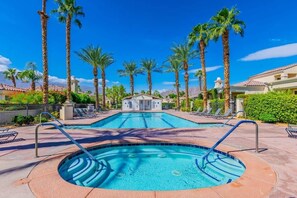 A swimming pool with a circular hot tub in the center, surrounded by palm trees and lounge chairs. - Desert Oasis: Close to Pools, Golf and Coachella! (La Quinta)