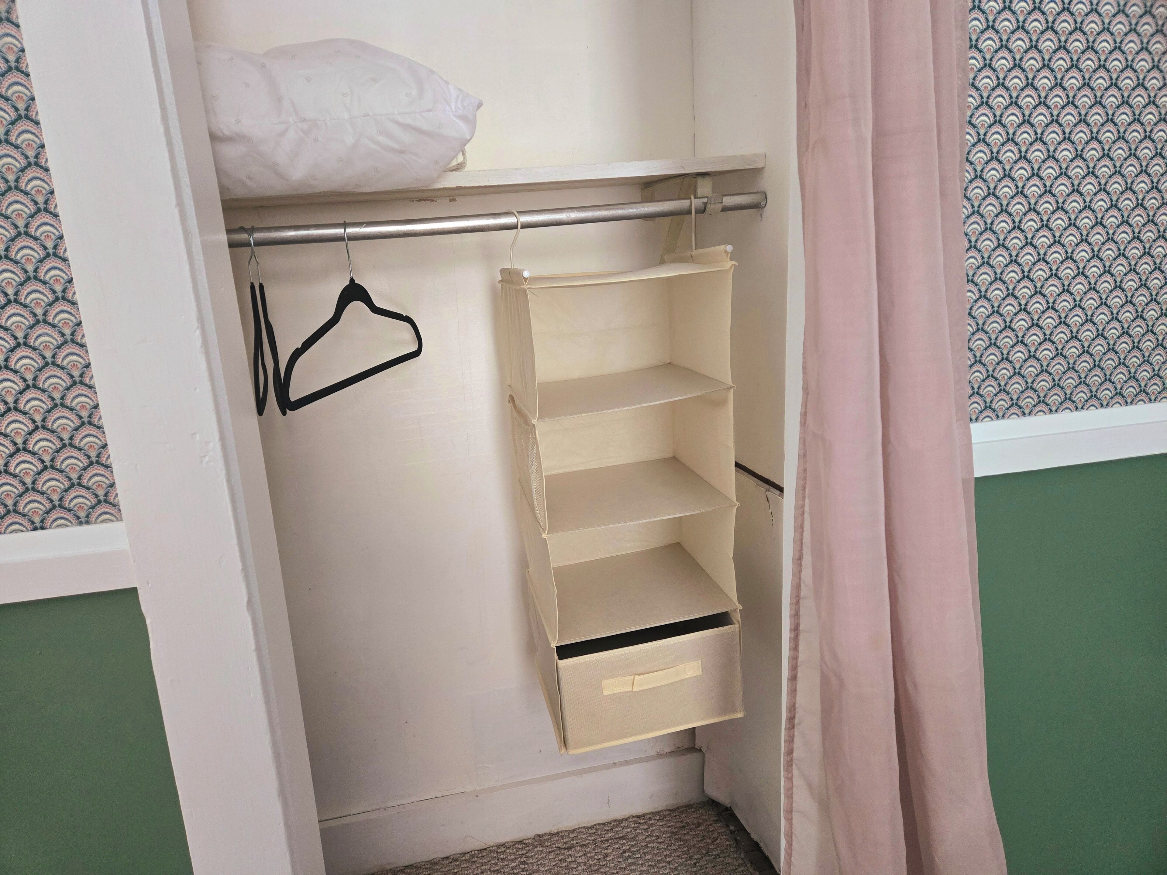 Ein Kleiderschrank mit Kleiderstange und Einlegeböcken.