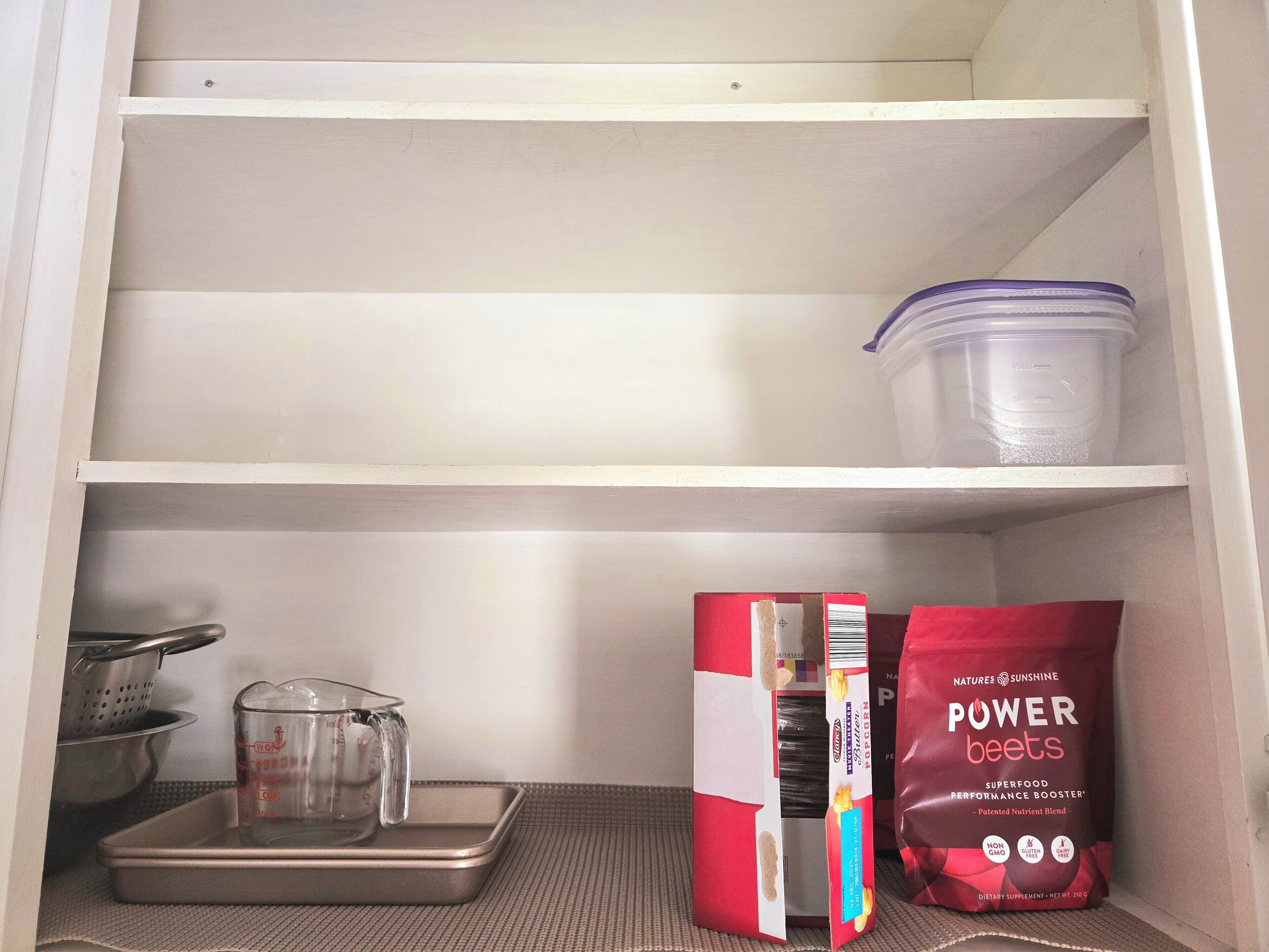 A pantry with shelves, a measuring cup, a colander, and bags of Power Beet Superfood.
