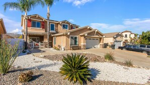 A two-story house with a garage, a front porch, and a driveway. - Lakeview Retreat in Elsinore with Pool & Hot Tub (Lake Elsinore)