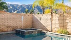 A swimming pool with a brick wall, a hot tub, and a view of mountains. - Lakeview Retreat in Elsinore with Pool & Hot Tub (Lake Elsinore)