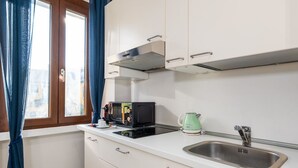 Eine Küche mit Mikrowelle, Wasserkocher und Spüle.