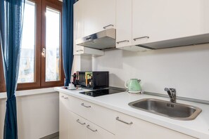 A kitchen with a microwave, kettle, and sink. - Peaceful 1-Bedroom Flat | Steps from Metro (M1) (Milano)