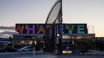 A building with a large illuminated sign spelling 'WHATEVER' in neon lights.