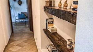 Ein Flur mit einem Holzboden und einem Regal, auf dem Bücher und Dekoration stehen.
