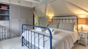 A bedroom with a bed, bedside table, lamp, and wardrobe. - Archway House - Blockley, Moreton-in-Marsh (Blockley)