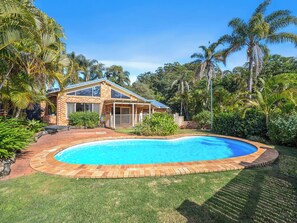 A house with a swimming pool surrounded by lush greenery and palm trees. - Tropic Lodge by Charlesworth (Coffs Harbour)
