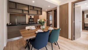 A modern kitchen with wooden cabinets and a dining area with a wooden table and chairs. - Brand New 2 BR Condo in Reforma - Queen Beds (Mexico City)