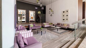 Uma sala de estar moderna com sofás, uma mesa de centro e luminárias pendentes.