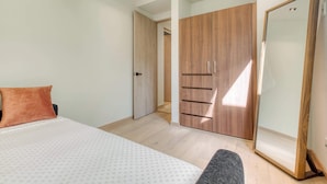 A bedroom with a bed, a wardrobe, and a mirror. - Centric 2 BR Condo in the Heart Roma Norte (Mexico City)
