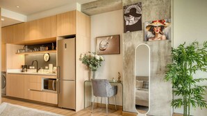 Eine moderne Küche mit Holzausbau, einem eingebauten Backofen und einem Essbereich mit grauem Stuhl und weißem Tisch.