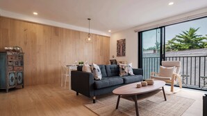 Una sala moderna con un sofá, una mesa de centro y un comedor con mesa y sillas.